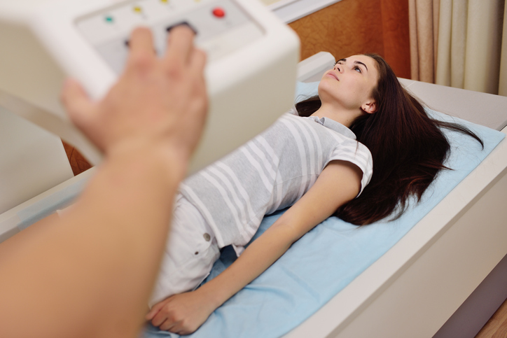 young pretty girl on examination in a modern clinic by densitometry